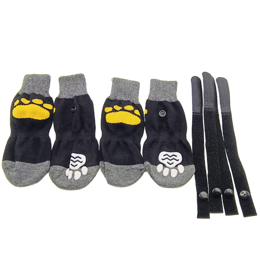 Set of black dog socks with yellow paw prints and gray accents, accompanied by black straps.