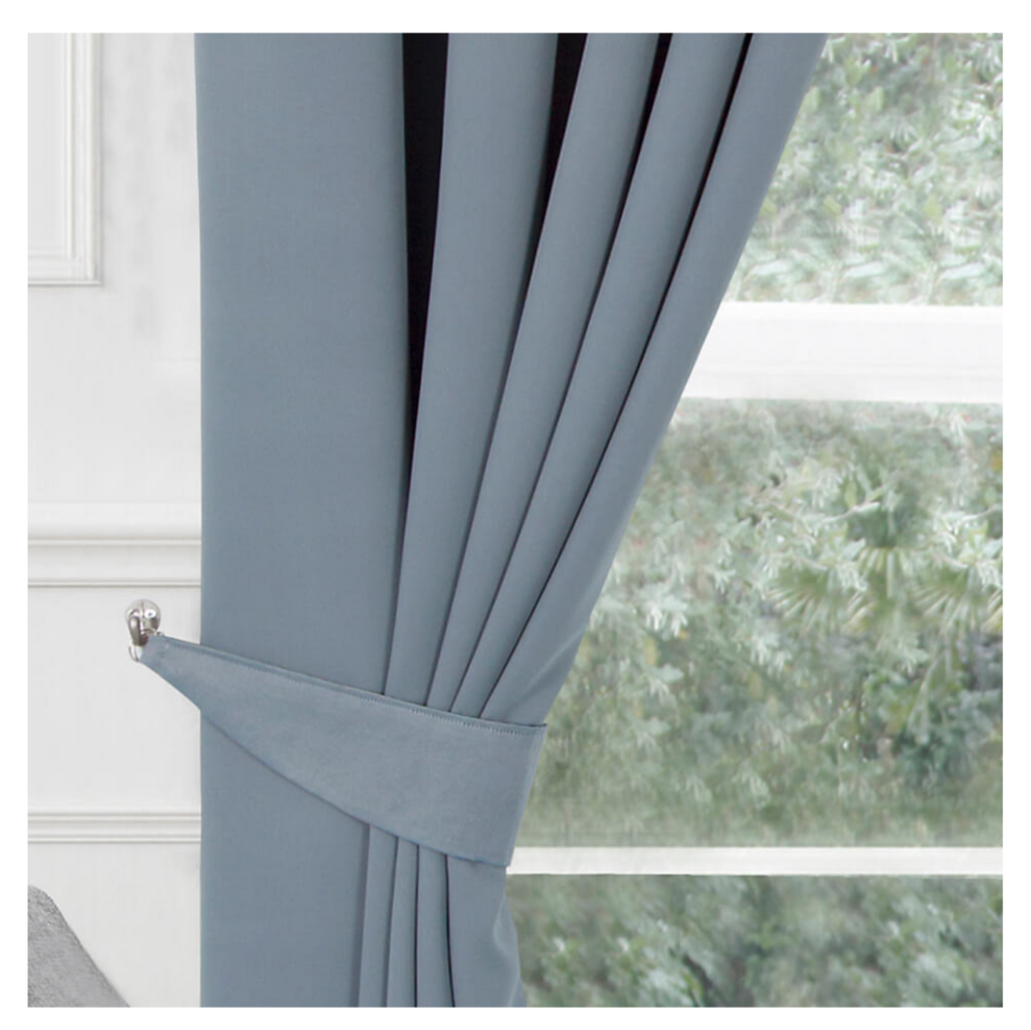 Gray curtain with tieback in front of a window with a blurred outdoor view