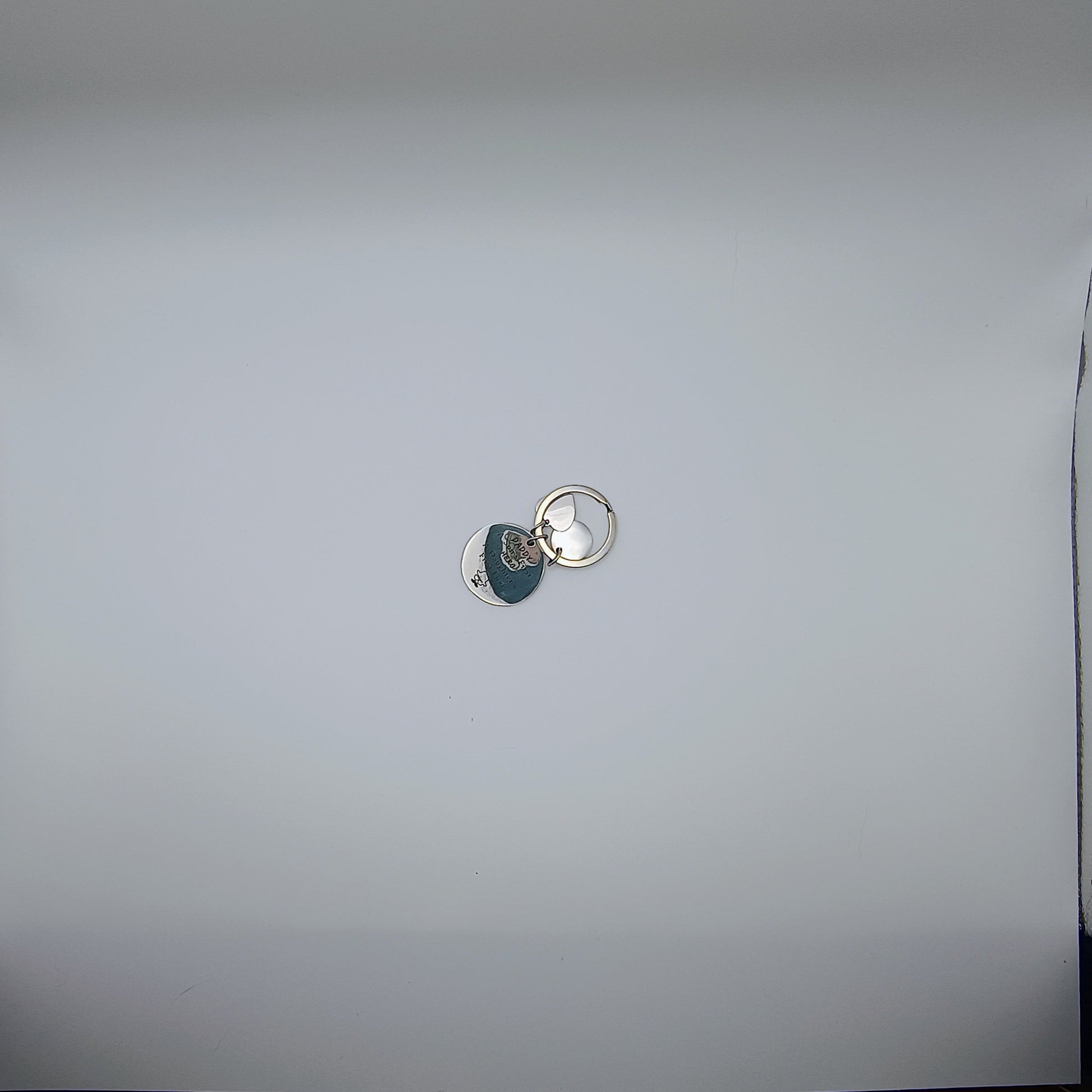 Keychain with a small round tag attached to a white surface