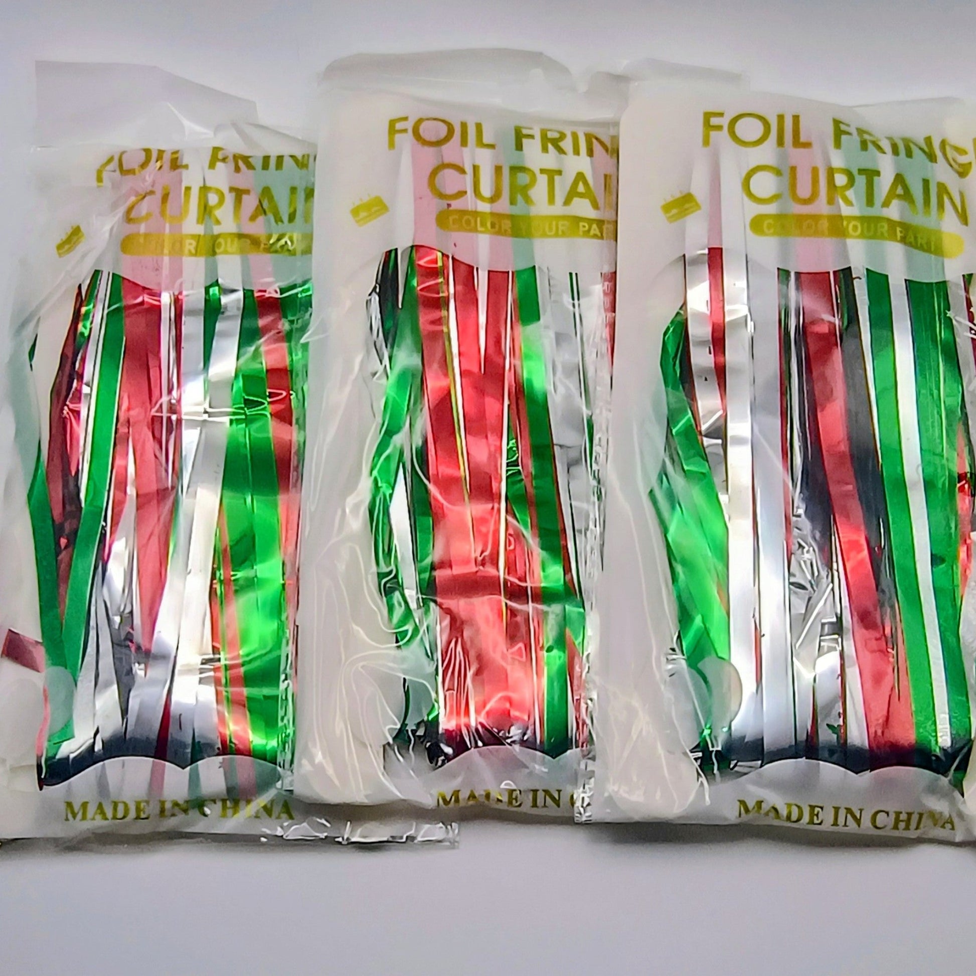 Three packages of foil fringe curtain on a white background