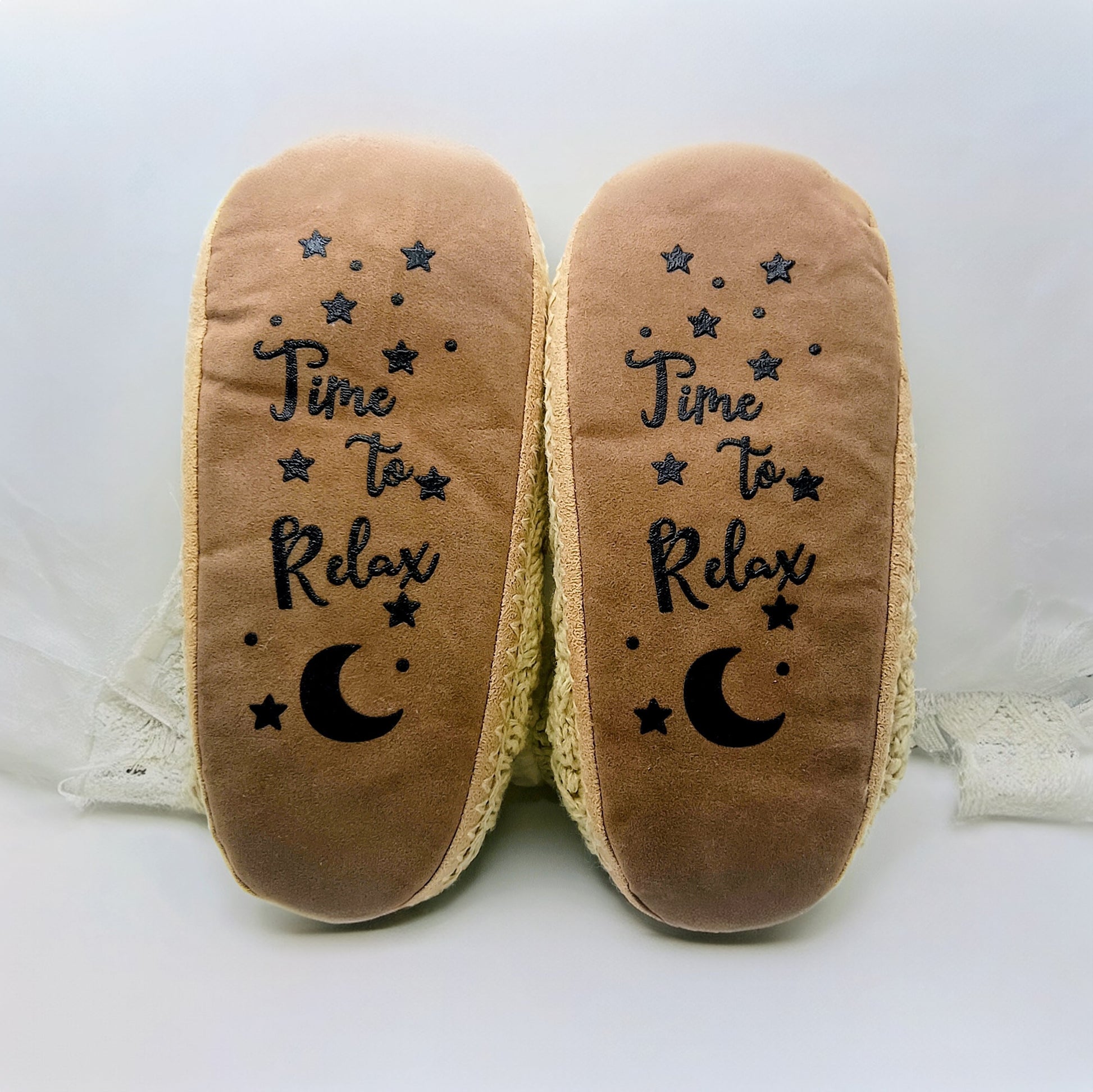 Pair of slippers with 'Time to Relax' text and moon design on a white background