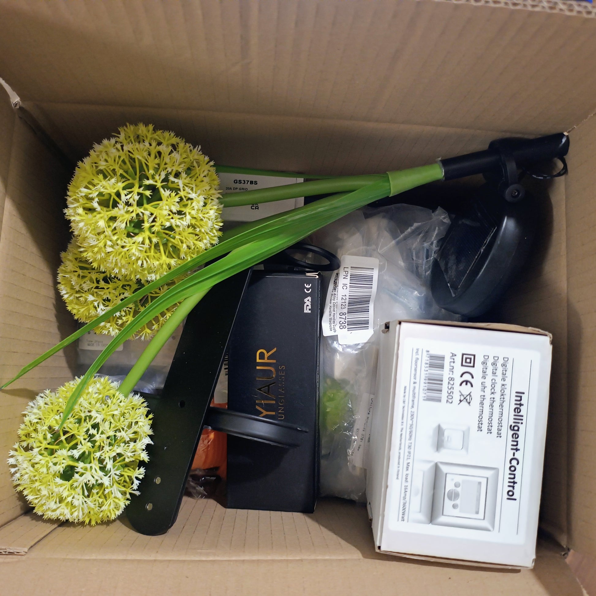 Box containing artificial plants and electronic components.