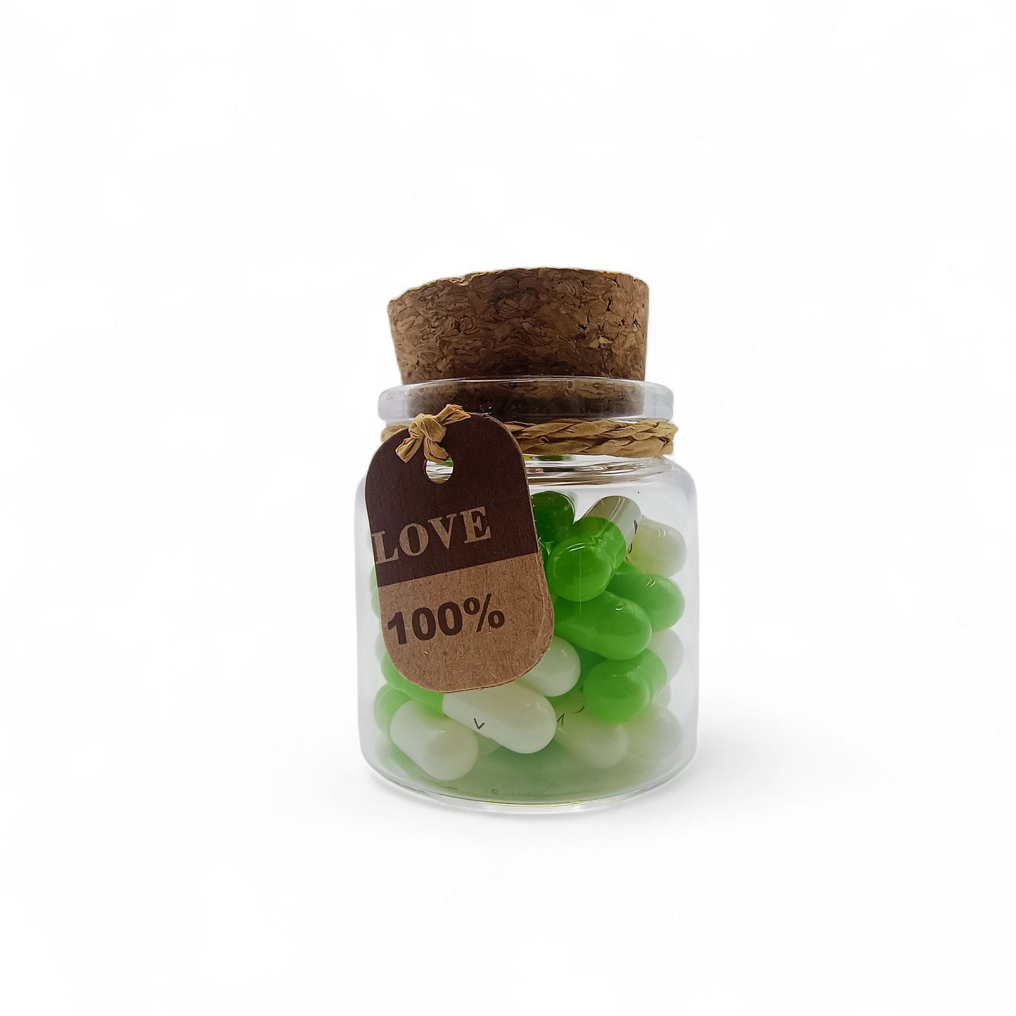 Small glass jar with green and white candies and a 'Love 100%' tag on a white background