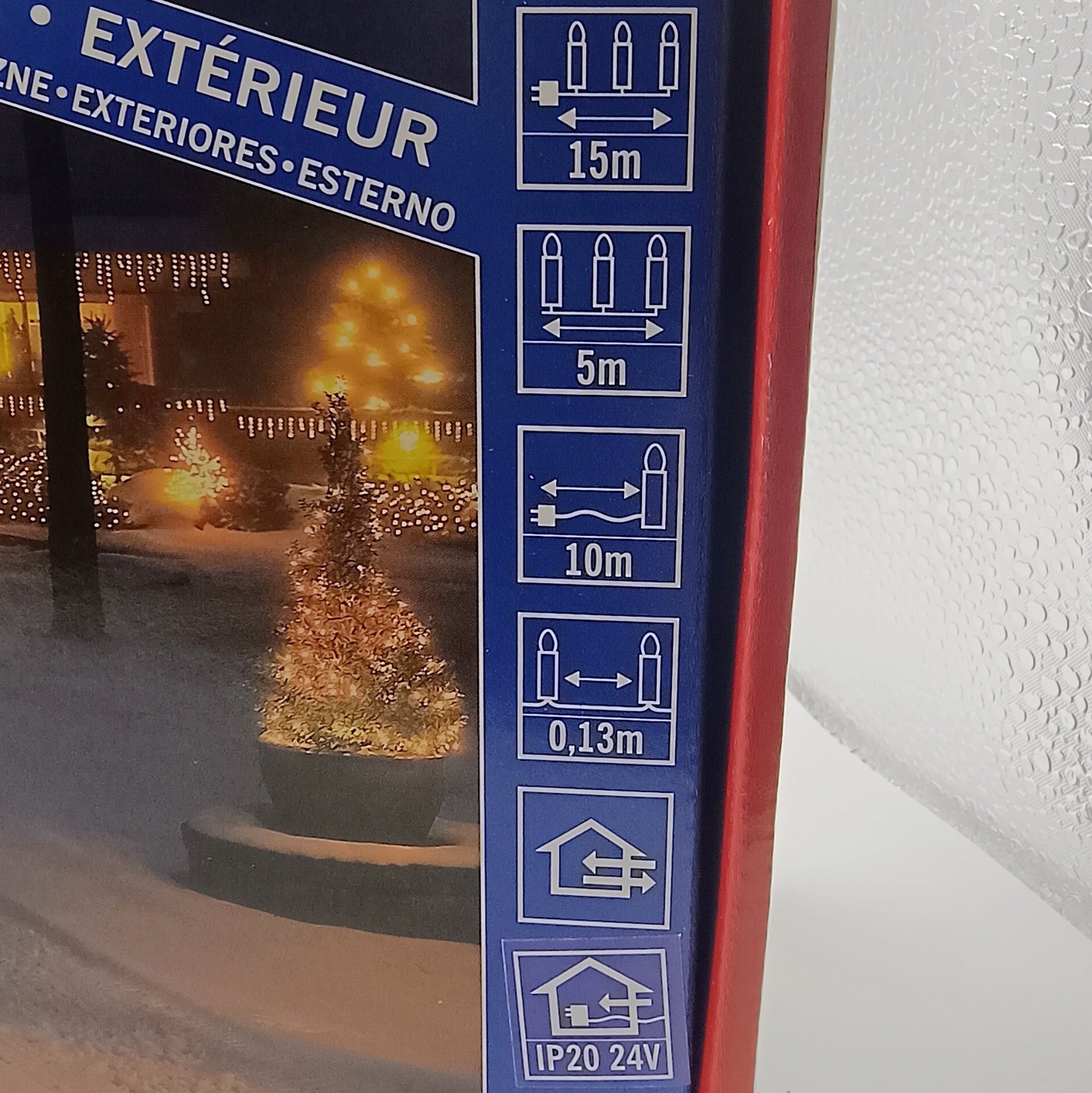 Box of outdoor string lights with illustrations and text on a white surface