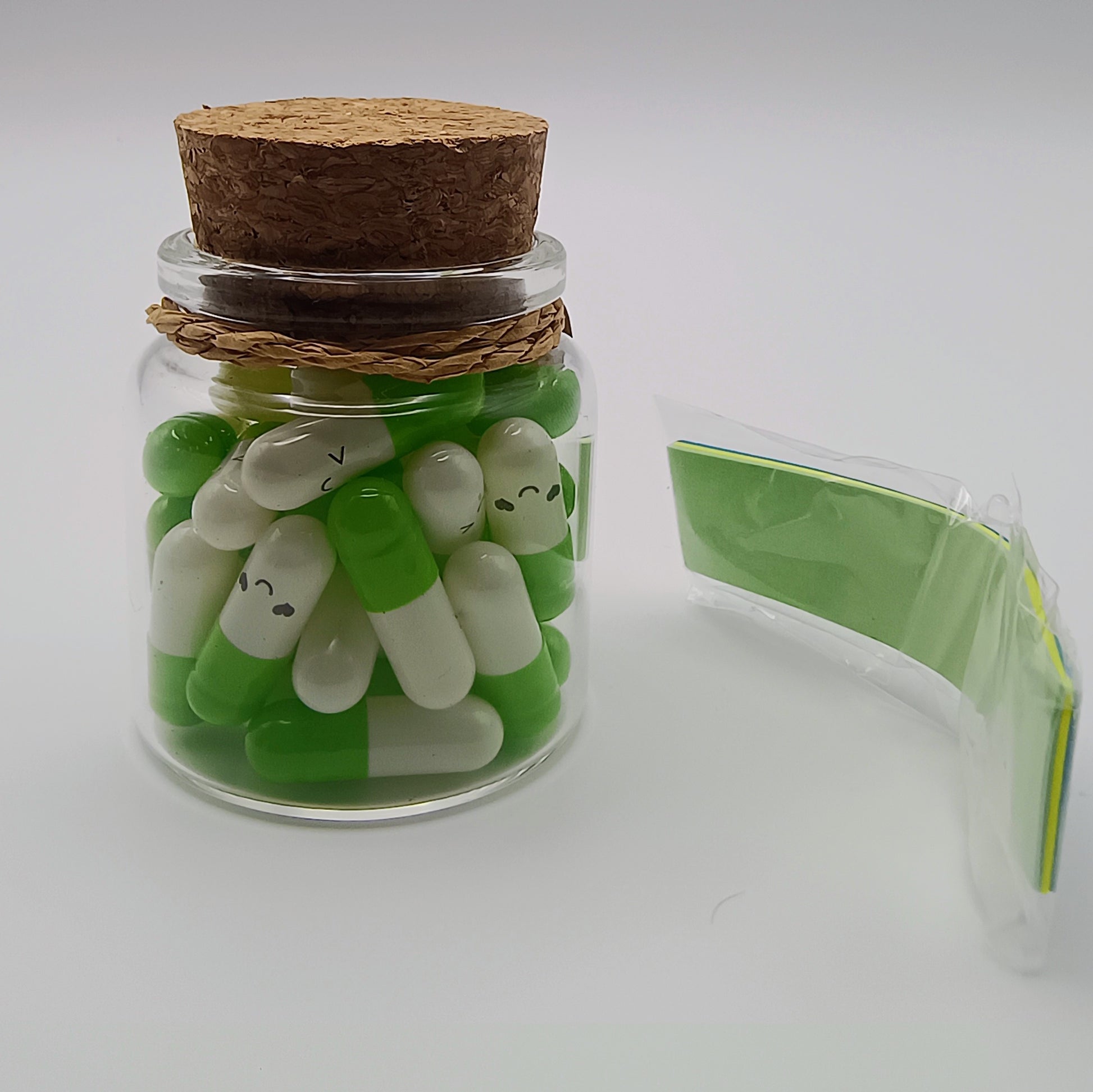 Jar of green and white candy with a cork lid on a white background